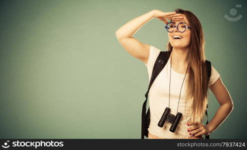 Summer holidays and tourism concept. Attractive woman long hair with backpack glasses holding binocular filtered photo