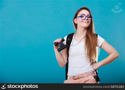 Summer holidays and tourism concept. Attractive woman long hair with backpack holding binocular on blue