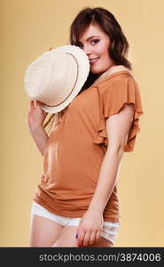 Summer holidays and vacation. Attractive girl holds summer straw hat covering her face having fun