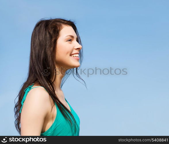 summer holidays and vacation - beautiful smiling girl over blue sky