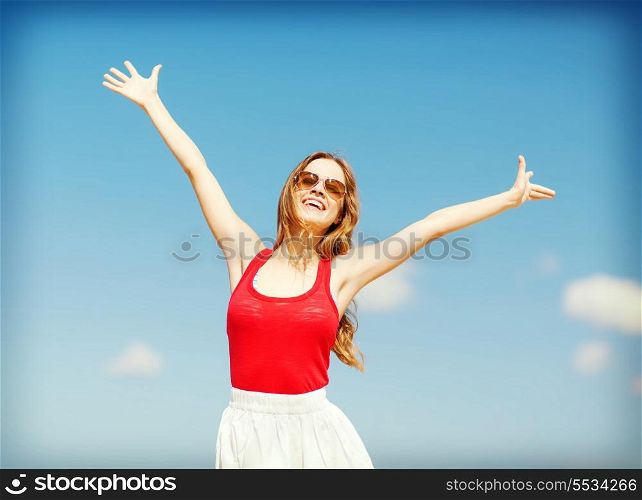 summer holidays and vacation concept - girl holding hands up on the beach