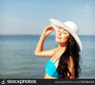 summer holidays and vacation concept - girl in bikini standing on the beach. girl in bikini standing on the beach