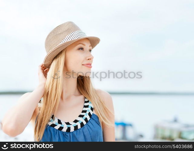 summer holidays and vacation concept - girl in hat standing on the beach