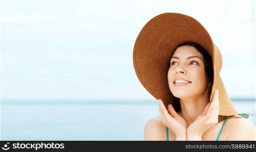 summer holidays and vacation concept - girl in hat standing on the beach. girl in hat standing on the beach