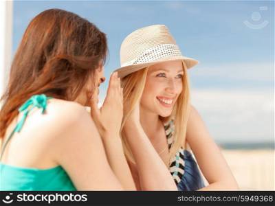 summer holidays and vacation concept - girls gossiping in cafe on the beach. girls gossiping in cafe on the beach