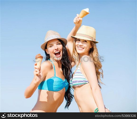 summer holidays and vacation concept - girls in bikini with ice cream on the beach