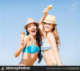 summer holidays and vacation concept - girls in bikini with ice cream on the beach