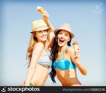 summer holidays and vacation concept - girls in bikini with ice cream on the beach