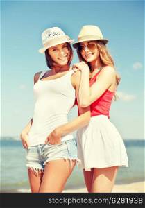 summer holidays and vacation concept - girls in hats on the beach