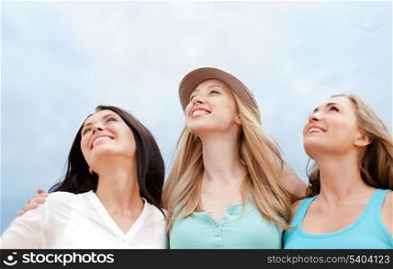 summer holidays and vacation concept - girls looking up in the sky