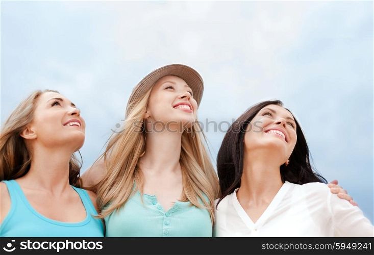 summer holidays and vacation concept - girls looking up in the sky. girls looking up in the sky