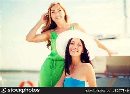 summer holidays and vacation concept - girls on boat or yacht