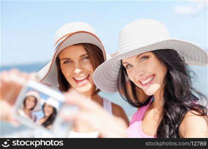 summer holidays and vacation concept - girls taking self portrait on the beach