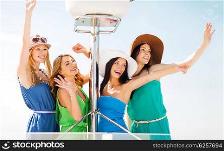 summer holidays and vacation concept - girls waving on boat or yacht. girls waving on boat or yacht