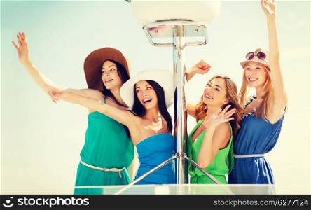summer holidays and vacation concept - girls waving on boat or yacht