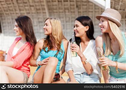 summer holidays and vacation concept - girls with drinks on the beach