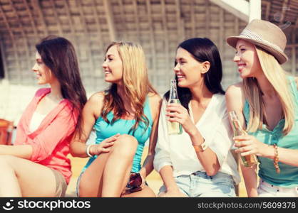 summer holidays and vacation concept - girls with drinks on the beach