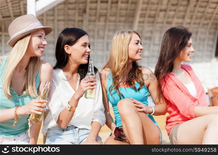 summer holidays and vacation concept - girls with drinks on the beach. girls with drinks on the beach