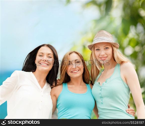 summer holidays and vacation concept - group of smiling girls chilling on the beach