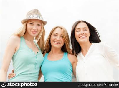 summer holidays and vacation concept - group of smiling girls chilling on the beach. group of smiling girls chilling on the beach