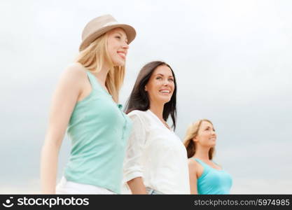 summer holidays and vacation concept - group of smiling girls chilling on the beach. group of smiling girls chilling on the beach