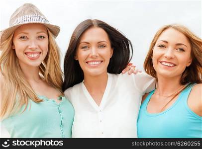 summer holidays and vacation concept - group of smiling girls chilling on the beach. group of smiling girls chilling on the beach