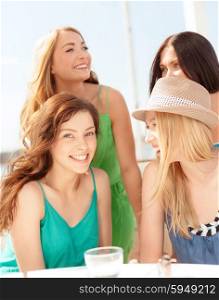summer holidays and vacation concept - group of smiling girls in cafe on the beach. group of smiling girls in cafe on the beach