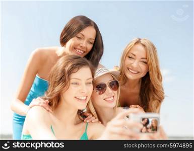 summer holidays and vacation concept - smiling girls taking photo in cafe on the beach. smiling girls taking photo in cafe on the beach
