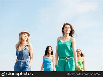 summer holidays and vacation concept - smiling girls walking on the beach