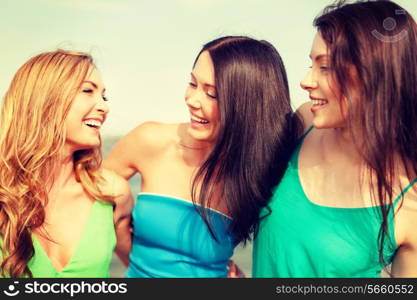 summer holidays and vacation concept - smiling girls walking on the beach