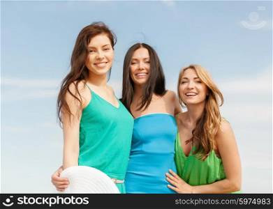 summer holidays and vacation concept - smiling girls walking on the beach. smiling girls walking on the beach