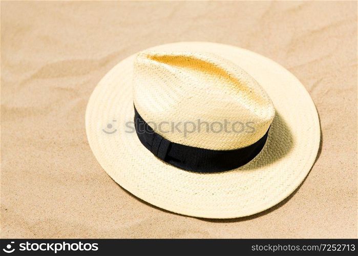 summer holidays and vacation concept - straw hat on beach sand. straw hat on beach sand