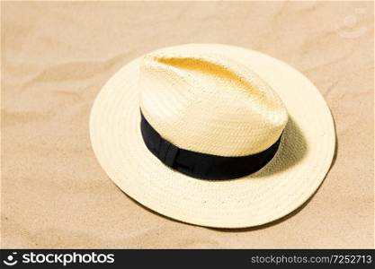 summer holidays and vacation concept - straw hat on beach sand. straw hat on beach sand