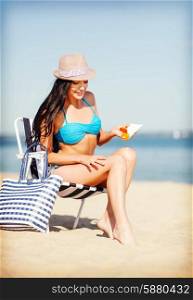 summer holidays and vacation - girl applying sun protection cream