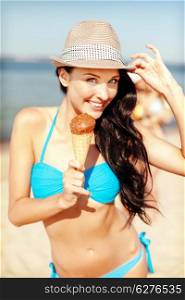 summer holidays and vacation - girl in bikini eating ice cream on the beach
