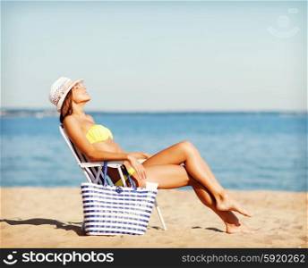 summer holidays and vacation - girl in bikini sunbathing on the beach chair. girl sunbathing on the beach chair