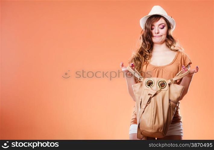 Summer holidays and vacation. Girl in fashionable clothes straw hat holding bag handbag looking for something. Woman funny face expression on brown