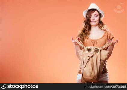 Summer holidays and vacation. Girl in fashionable clothes straw hat holding bag handbag looking for something. Woman funny face expression on brown