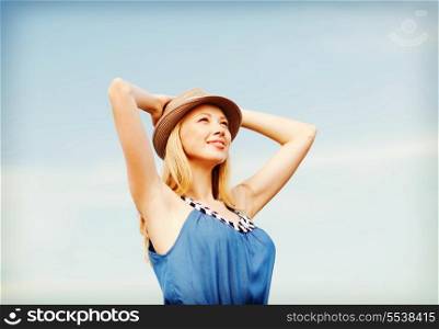 summer holidays and vacation - girl in hat standing on the beach