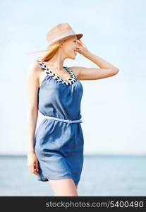 summer holidays and vacation - girl in hat walking on the beach