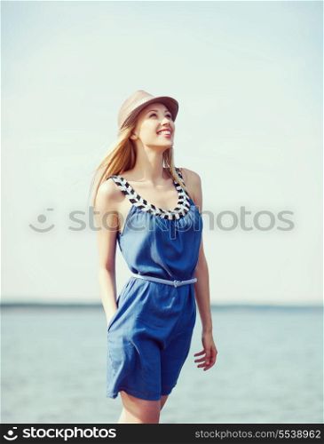 summer holidays and vacation - girl in hat walking on the beach