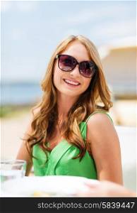 summer holidays and vacation - girl in shades in cafe on the beach. girl in shades in cafe on the beach