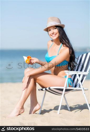 summer holidays and vacation - girl putting sun protection cream on the beach chair