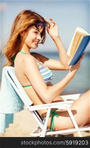 summer holidays and vacation - girl reading book on the beach chair. girl reading book on the beach chair