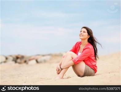 summer holidays and vacation - girl sitting on the beach