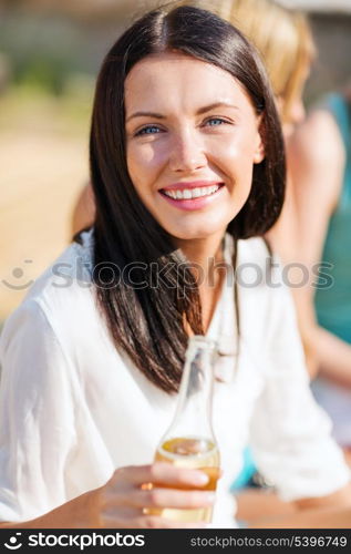 summer holidays and vacation - girl with drink and friends on the beach