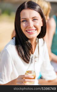 summer holidays and vacation - girl with drink and friends on the beach