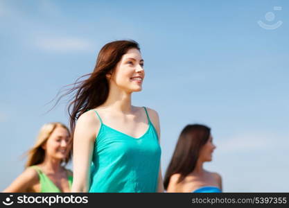 summer holidays and vacation - girl with friends walking on the beach