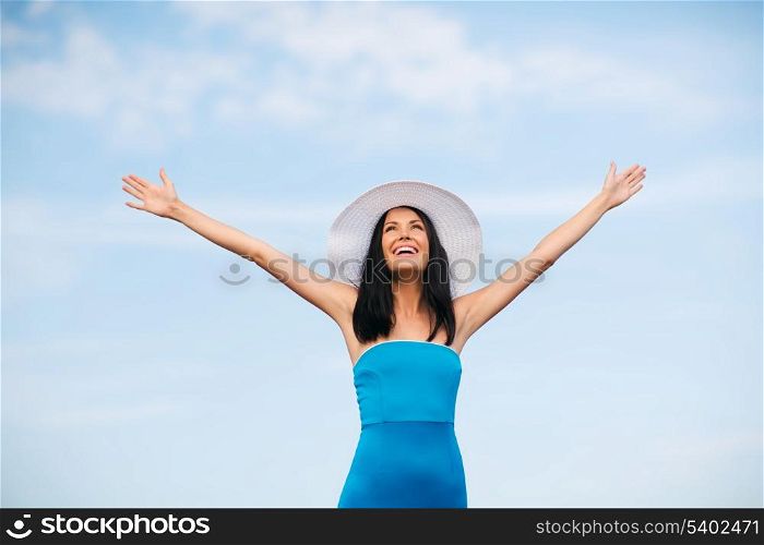 summer holidays and vacation - girl with hands up on the beach