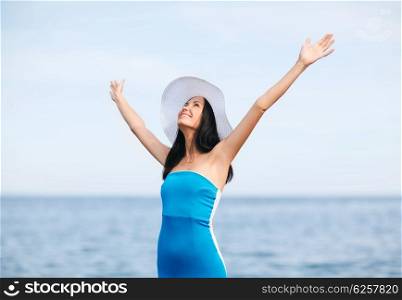 summer holidays and vacation - girl with hands up on the beach. girl with hands up on the beach